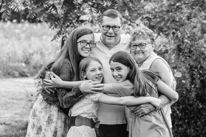 Balck and white portrait of grandparents group hug with their grandchilder