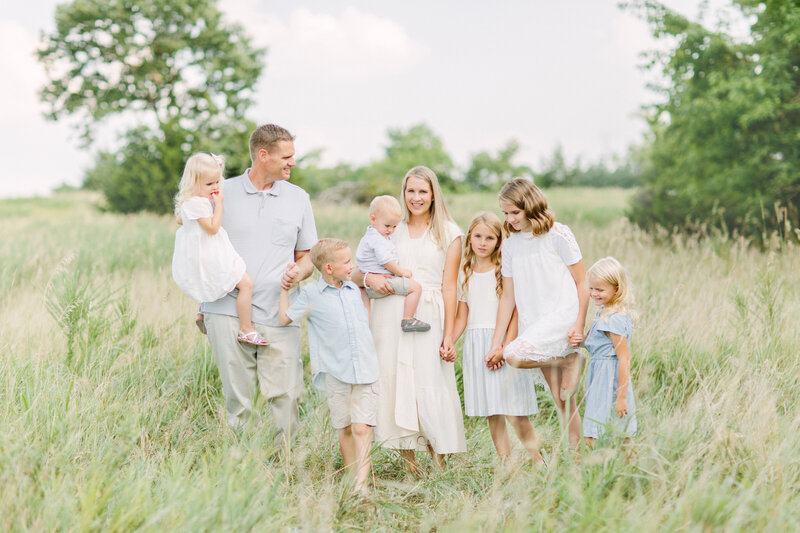 Mom wearing a pink dress holding her baby daughter's hands. Kansas City photography by Jeanna Hayes