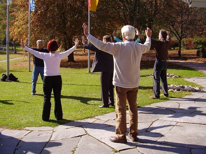 people in a park gathered to do tai chi gung  class