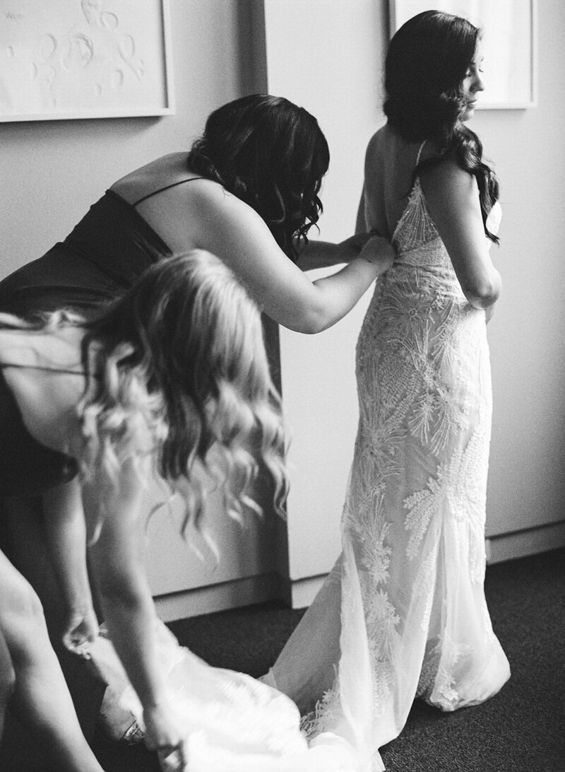 Bride-getting-dressed-with-bridesmaids