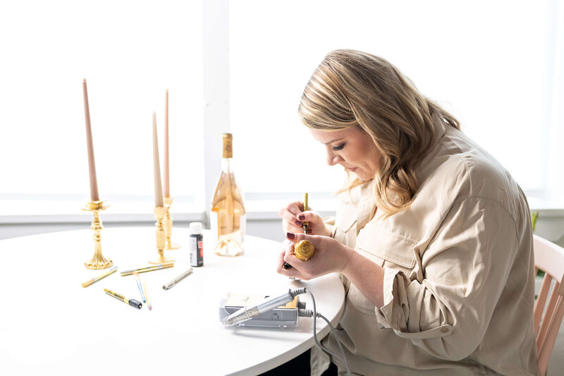 Sarah Henry writing on a champagne bottle