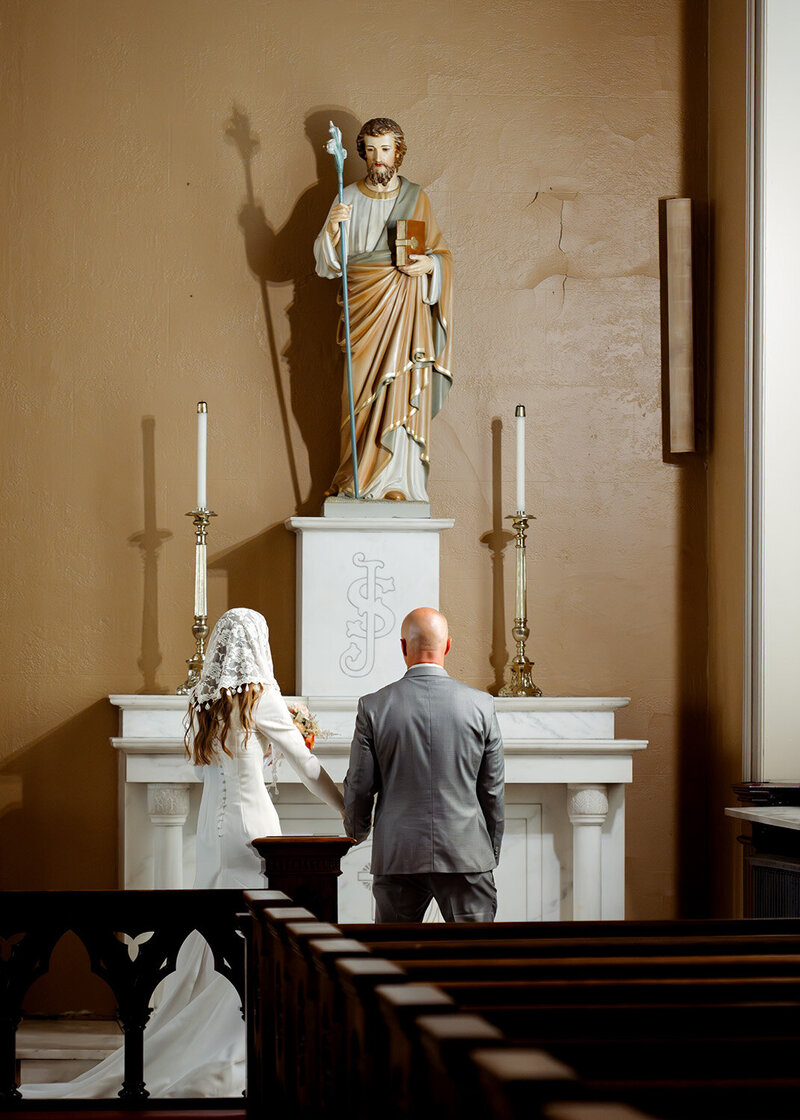 A catholic couple gives flowers to st. joseph during their traditional catholic wedding mass at St. Mary's in downtown Nashville, TN