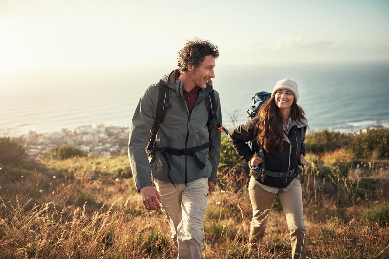 Young couple hiking with water in background