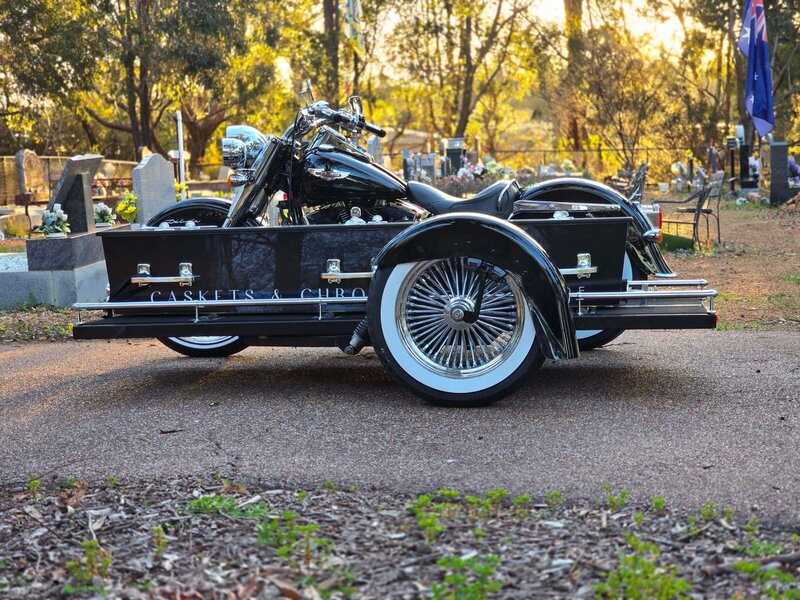 Harley Davidson hearse carrying a casket at a Perth cemetery, providing a personalised farewell.