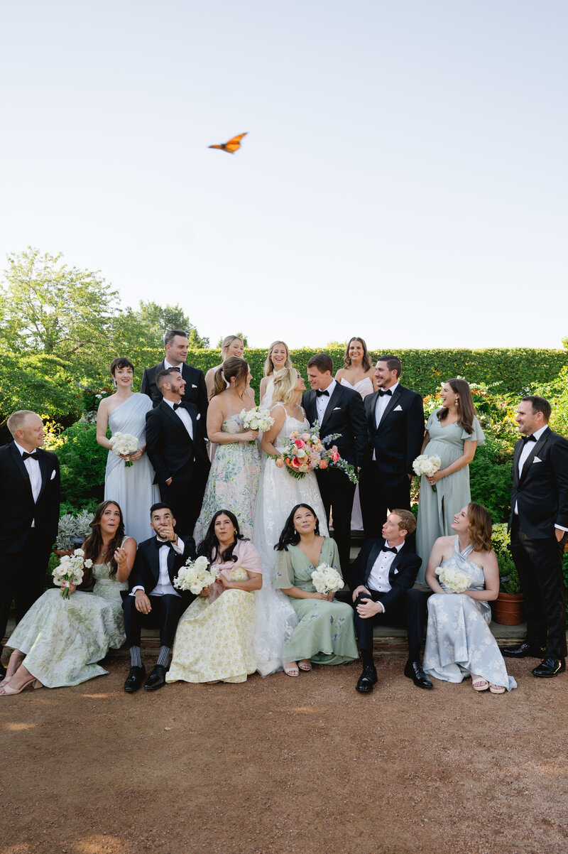 The bridal party posing for a group picture on a sunny day. 