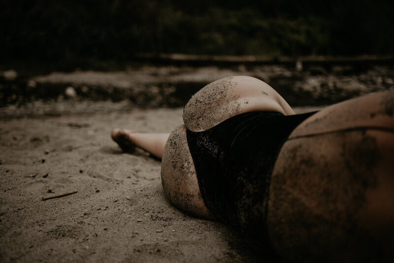 Girl rolling around in sand in Maple Ridge creek