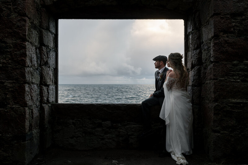 couple look out to sea during their castle elopement in scotland