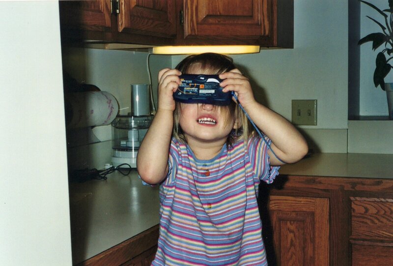 child brianna holding a film camera the wrong way to her face