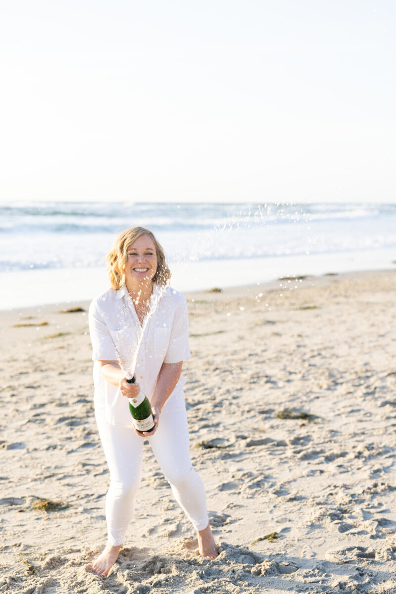 Lis popping champagne on the beach