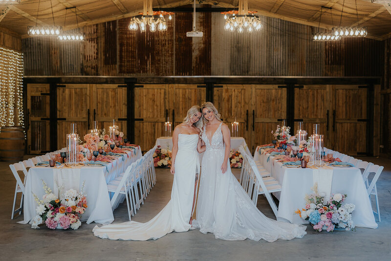 Hunter Valley based Wedding Photographer specialising in relaxed natural  photos. Couple embraces, looking gorgeous and relaxed. LGBTQIA Friendly Ally. This image shows two girls getting married and both of Wedding Dresses in a Hunter Valley Barn.