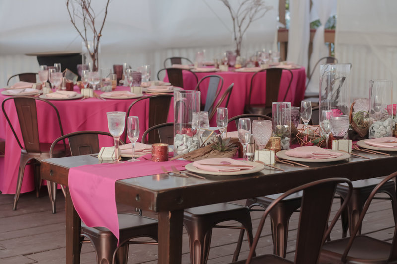Farm table with copper chairs with fuchsia linens