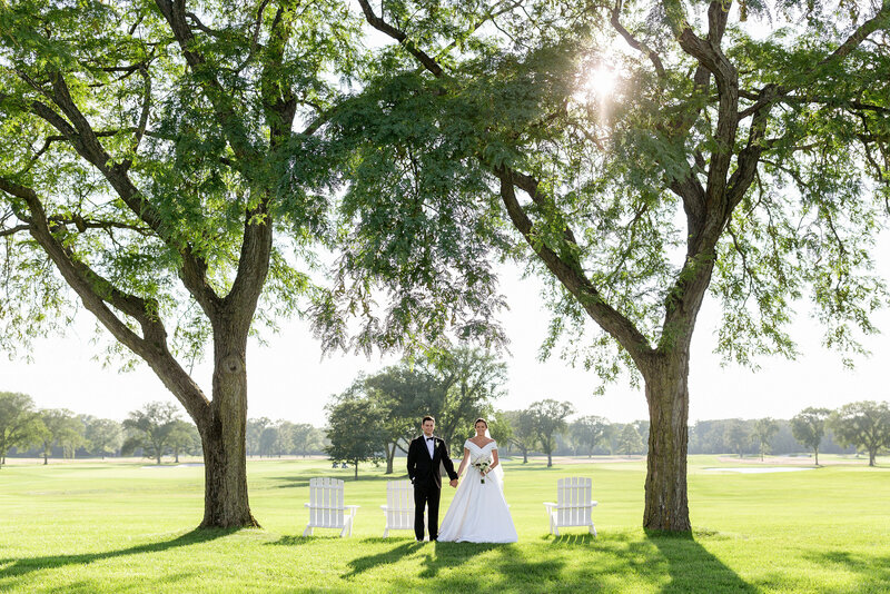 clean and modern posed photo of bride and groom in between two trees at Knollwood Club