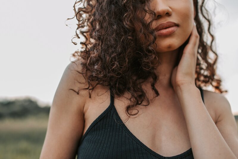 girl with curly hair wearing tank top