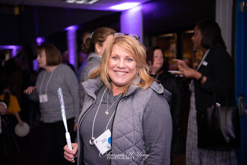 A woman is smiling and having a great time at the Wayne YMCA fundraising event.