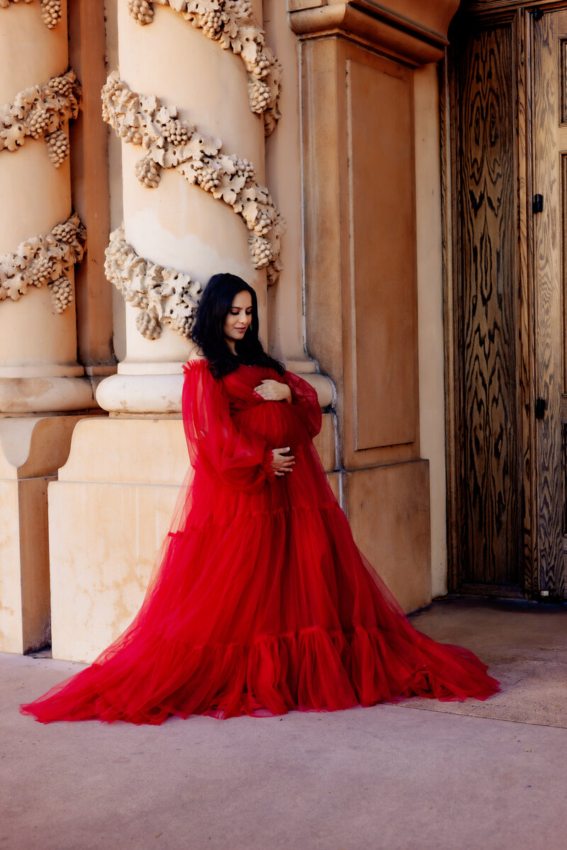 Maternity Photographer, a pregnant woman holds her belly at Balboa Park