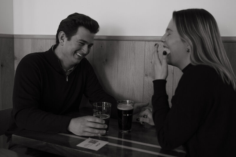 couple laughs over beers