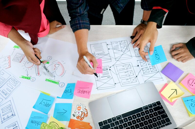 An image displaying the hands on team members sketching in a workshop