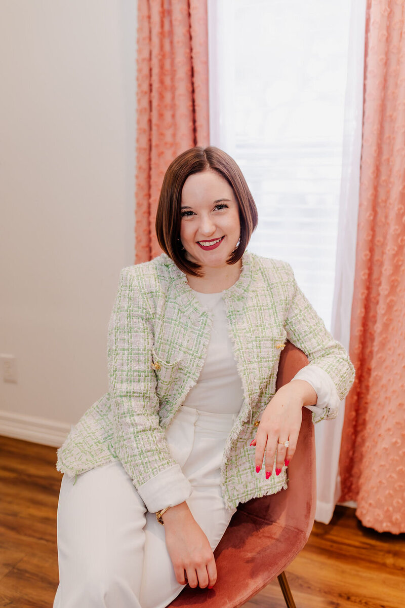 Woman wearing pink pant suit smiling for camera