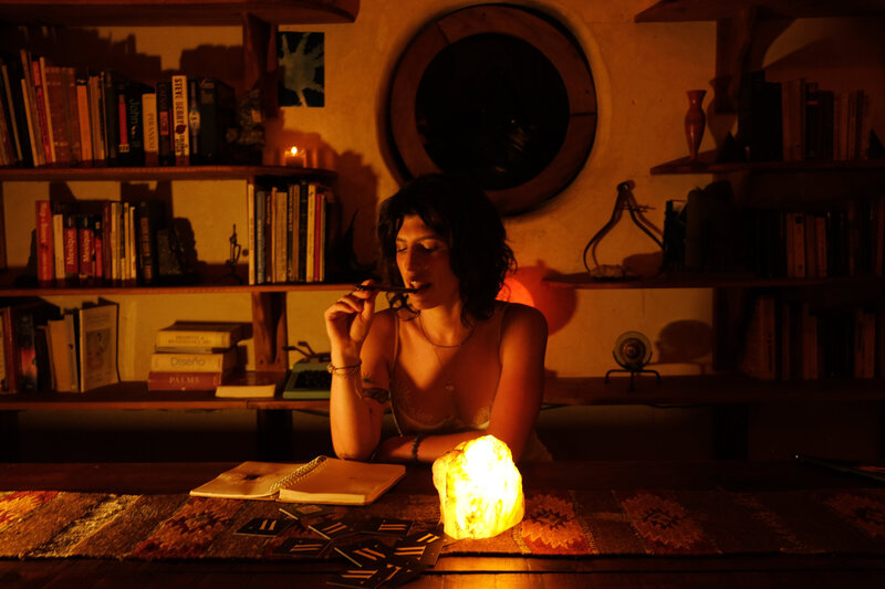 Tristan Thibodeau writing in a cozy space illuminated by candlelight, surrounded by books and personal artifacts—capturing intuitive leadership in brand building.