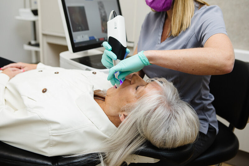 Expert prosthodontist at Peak Prosthodontics placing a custom dental implant to restore a patient’s smile and function. Serving Lethbridge, Alberta and surrounding areas.