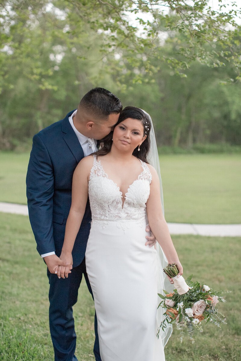 a new husband embraces his bride while she holds her bouquet