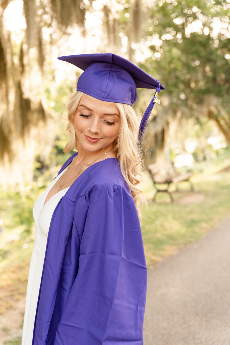 Graduate looking down off shoulder during a photo shoot
