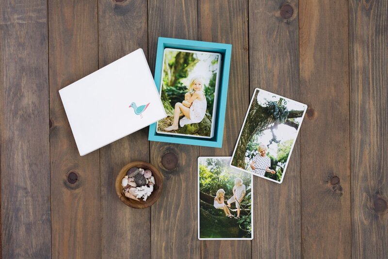 An assortment of photo prints on a wood table.
