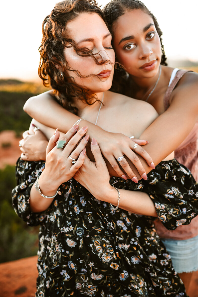 Bell Rock, Sedona mother and daughter hugging at sunset while the cool breeze blows their hair.