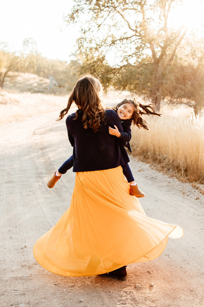 Mom holding and kissing her toddler daughter for a family photography session in San Luis Obispo