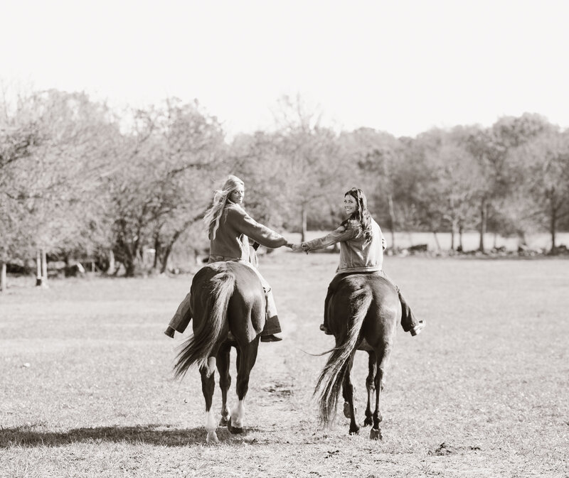 Black and white photo of two girls riding 