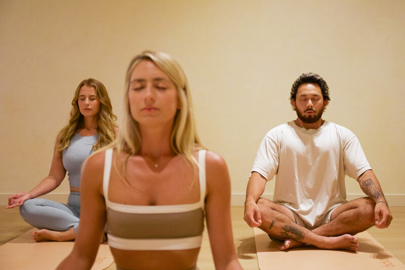 A group of people doing breathwork in a relaxing yoga studio.