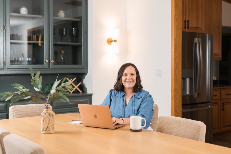 woman working at a laptop with a glass of wine