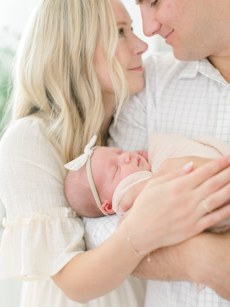 new parents holding their newborn baby girl