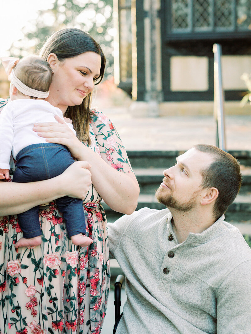 A mother and father looking at each other as the mother holds their baby by Katie Stansfield Photography, a Richmond family photographer.