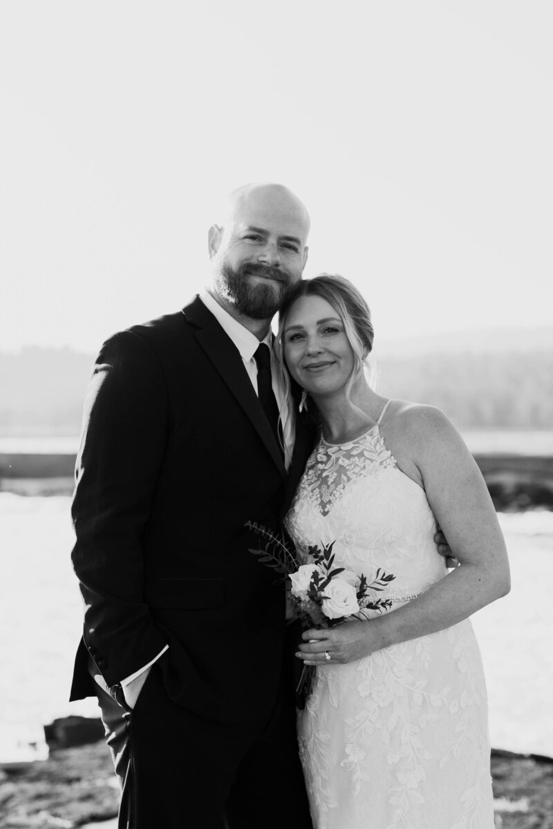 A newlywed couple standing side by side smiling 