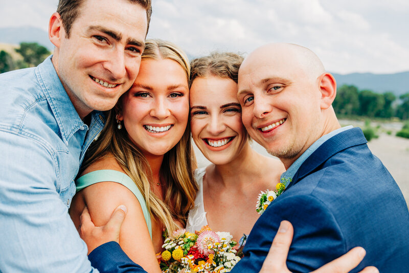 Bride and groom huddling with friends at Miles Park Band Shell in Livingston, MT
