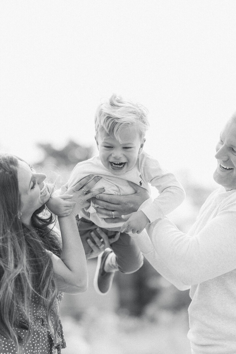 little boy picked up by his dad laughing during family session with washington dc family photographer costola photography