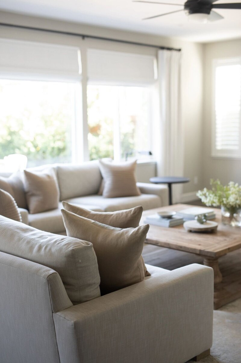 An organic, contemporary interior design with cream colored couches and a low wooden coffee table