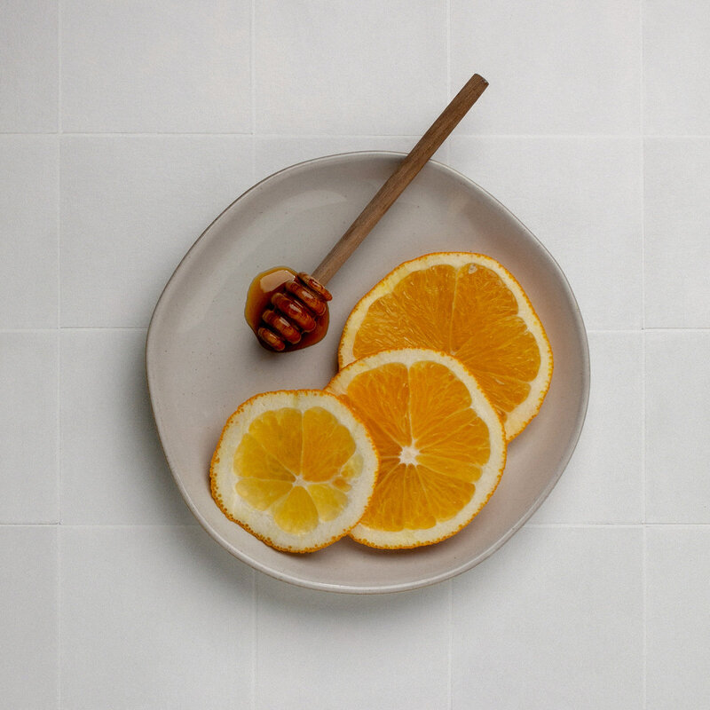 orange slices with honey on a plate on tile counter