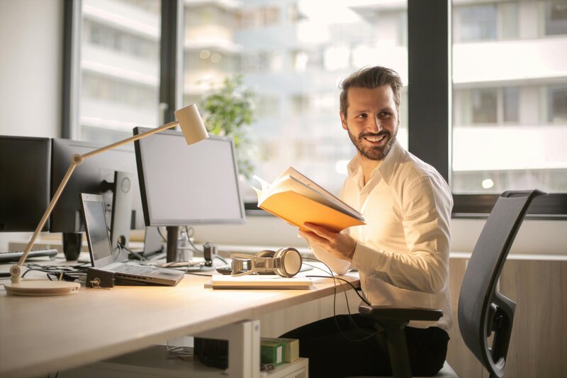 A man at his desk smiling
