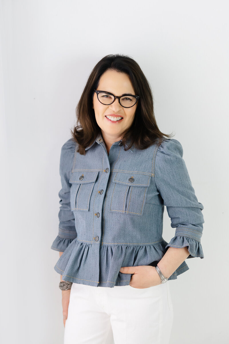 Leadership coach smiling in denim jacket symbolizing approachable confidence