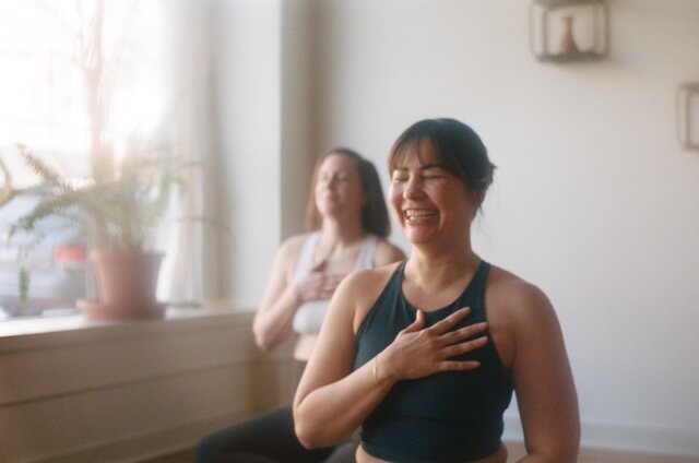 A woman is gently holding her hands together, conveying a sense of calm and contemplation.