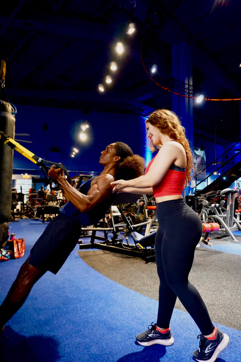 Elizabeth West, Boca Raton’s best personal trainer, teaching a client to perform an inverted row on the TRX machine.