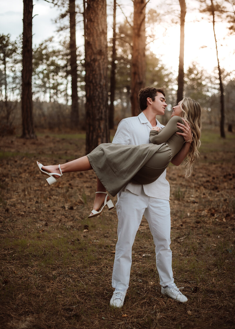A man holding his girlfriend and spinning her at Dawson Butte Open Space Colorado. 