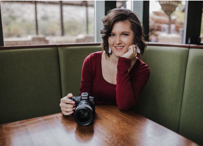 oklahoma photographer and coach Brooke Jefferson sits with camera in hand smiling
