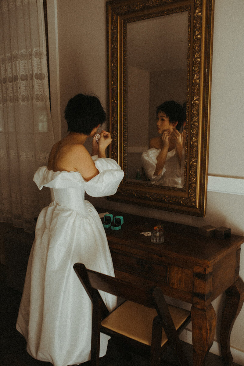 A bride looks in the mirror on her wedding day