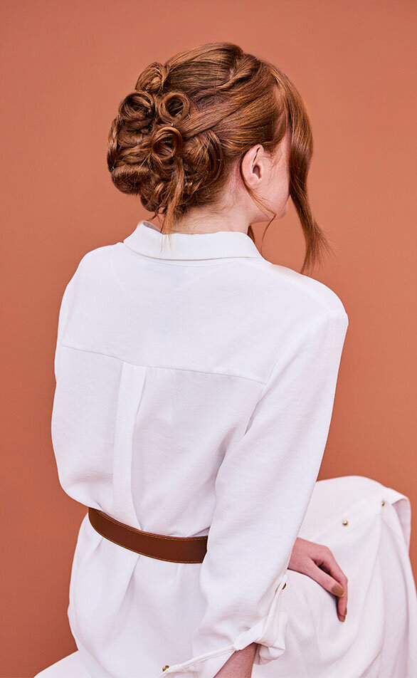 Elegant bridal updo with intricate curls and twists on red hair, styled in a luxury Sydney hair salon.