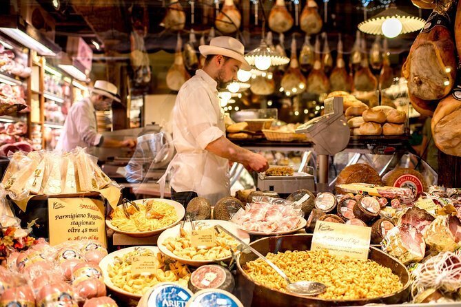 Italian vendors preparing meats, cheeses, and pasta inside Bologna’s historic food market—a sensory highlight of the Wish You WERE Here Italy Tour with author Christy Schillig.