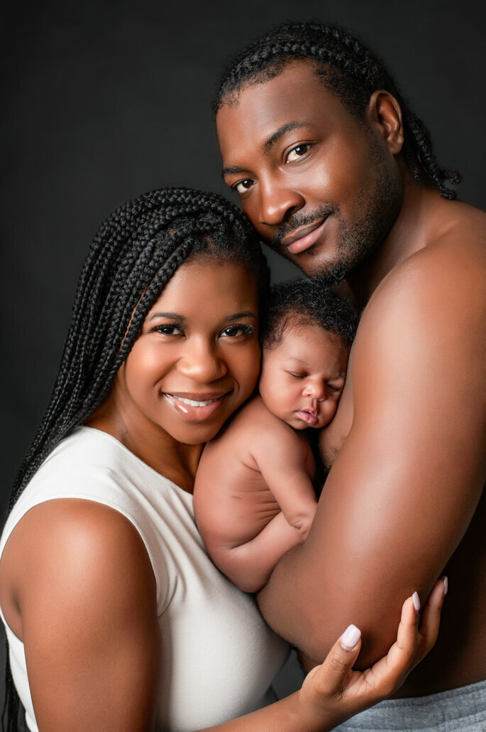 New parents holding their newborn baby during a Bump to Baby family photography session in Birmingham, Alabama
