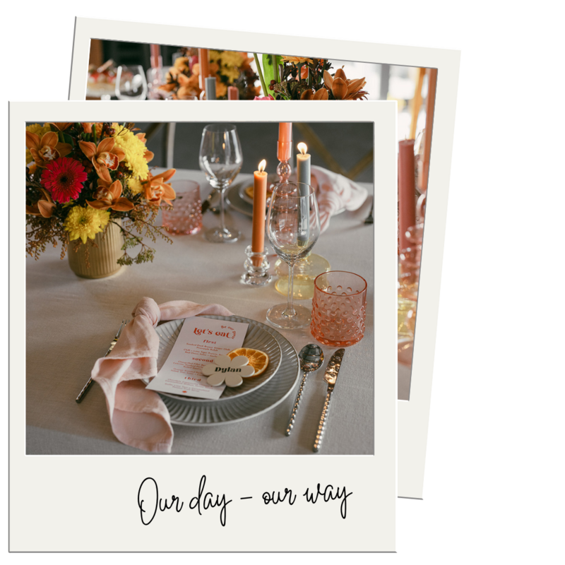 Table setting with bloom of florals, pink water glasses, pink napkins and colourful candles